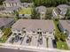 Community aerial view featuring townhouses with attached garages, well-maintained landscaping, and parking at 4262 Cloud Hopper Way, Lutz, FL 33559