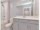 Well-lit bathroom featuring tiled shower, white vanity, large mirror, toilet and bathtub at 4262 Cloud Hopper Way, Lutz, FL 33559