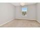 Bright and airy bedroom with neutral walls, plush carpet, and natural light from the window at 4262 Cloud Hopper Way, Lutz, FL 33559