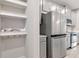 Gleaming stainless refrigerator adjacent to crisp white shelves, cabinets, and modern appliances at 4262 Cloud Hopper Way, Lutz, FL 33559