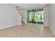 Open-concept living room with tile flooring, a staircase, and sliding glass doors to the backyard at 4262 Cloud Hopper Way, Lutz, FL 33559