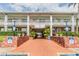 Covered entrance to Imperial Embassy Condo 3 is flanked by brick walls and lush plants at 4748 Azalea Dr # 204, New Port Richey, FL 34652