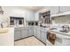 Cozy kitchen featuring white cabinets, appliances, and view into dining area at 4748 Azalea Dr # 204, New Port Richey, FL 34652