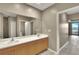 Bathroom featuring double sinks, cabinets, a large mirror, a shower, and views to outside balcony at 530 S Gulfview Blvd # 203, Clearwater Beach, FL 33767