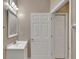 Bright bathroom featuring a vanity with sink and mirror with lighting and a white six-panel door at 530 S Gulfview Blvd # 203, Clearwater Beach, FL 33767