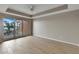 Bright bedroom featuring hardwood floors, ceiling fan, sliding glass doors, and large windows with water views at 530 S Gulfview Blvd # 203, Clearwater Beach, FL 33767