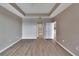 Large bedroom with hardwood floors, tray ceilings, and views into bathroom and hallway at 530 S Gulfview Blvd # 203, Clearwater Beach, FL 33767