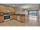 Well-lit kitchen with wood cabinets, stone countertops, and stainless steel appliances overlooks living area at 530 S Gulfview Blvd # 203, Clearwater Beach, FL 33767
