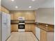 Bright kitchen with light wood cabinets, marble countertops, stainless steel appliances, and tile floors at 530 S Gulfview Blvd # 203, Clearwater Beach, FL 33767
