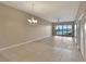 Spacious living room featuring tile floors, ceiling fan, chandelier, and sliding doors offering a waterfront view at 530 S Gulfview Blvd # 203, Clearwater Beach, FL 33767