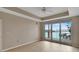 Bright living room with waterfront views from the large sliding doors and elegant tray ceiling with fan at 530 S Gulfview Blvd # 203, Clearwater Beach, FL 33767