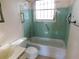 Green and white bathroom with grab bars and window at 5707 S 79Th St, Tampa, FL 33619