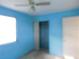 Bright blue bedroom features closet, door, and window at 5707 S 79Th St, Tampa, FL 33619
