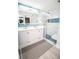 Modern bathroom featuring a dual sink vanity, illuminated mirror, and a tiled glass enclosed shower at 5712 Biscayne Ct # 201, New Port Richey, FL 34652