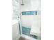 Stylish glass enclosed shower featuring blue tile accents, a built-in bench, and modern fixtures at 5712 Biscayne Ct # 201, New Port Richey, FL 34652