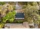 Overhead view of a home with lush green trees, and a grey roof, in a quiet, residential neighborhood at 5801 N 17Th St, Tampa, FL 33610