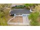 Aerial view of a well-maintained home with gray roof, landscaping, and convenient driveway with carport at 5801 N 17Th St, Tampa, FL 33610