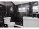 Modern bathroom featuring black and gold marble tile in the shower, along with a white vanity at 5801 N 17Th St, Tampa, FL 33610