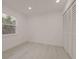 Vacant bedroom with light gray flooring, white walls, and a bi-fold door closet at 5801 N 17Th St, Tampa, FL 33610