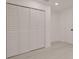 Vacant bedroom with light gray flooring, white walls, and a triple bi-fold door closet at 5801 N 17Th St, Tampa, FL 33610