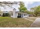A charming home with a well-kept lawn, a black-and-white exterior, and a quaint chimney at 5801 N 17Th St, Tampa, FL 33610