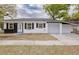 Charming single-story home with a black-and-white exterior, complemented by an attached carport and well-manicured lawn at 5801 N 17Th St, Tampa, FL 33610