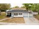 Charming one-story home featuring a blue-painted drive and walkway and a contrast of black and white facade at 5801 N 17Th St, Tampa, FL 33610