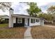 This beautiful home boasts a striking black-and-white exterior, a chimney, and a well-maintained front lawn at 5801 N 17Th St, Tampa, FL 33610