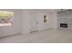 View of a living room featuring light colored flooring, an electric fireplace with stone accent wall and decorative front door at 5801 N 17Th St, Tampa, FL 33610