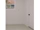 A vacant room features light gray flooring, white walls and trim, and a white door at 5801 N 17Th St, Tampa, FL 33610