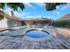 Beautiful backyard pool and spa surrounded by brick pavers, complemented by a screened-in patio at 605 Citrus Ct, Largo, FL 33770