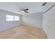 This bedroom features a ceiling fan, travertine floors, neutral paint, and a large window at 605 Citrus Ct, Largo, FL 33770