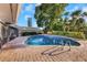 Sparkling blue in-ground pool with brick paver surround and mature landscaping at 605 Citrus Ct, Largo, FL 33770