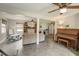 Spacious living room featuring tile floors, neutral paint, ceiling fans, and a piano at 611 Shore E Dr, Oldsmar, FL 34677
