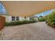 Paver driveway leading to a charming home, shaded by a canopy and surrounded by lush greenery at 6202 7Th S Ave, Gulfport, FL 33707