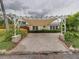 Front view of a home with a covered driveway featuring beautiful tropical landscaping at 6202 7Th S Ave, Gulfport, FL 33707