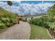 Paver driveway leading to a charming home surrounded by lush tropical landscaping at 6202 7Th S Ave, Gulfport, FL 33707