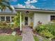 Welcoming front entrance with a tiled walkway, charming landscaping, and a cozy yellow chair at 6202 7Th S Ave, Gulfport, FL 33707