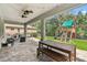 Covered back porch with ceiling fans, dining table, and outdoor living space overlooking the backyard with a playset at 6214 Windship Ct, Tampa, FL 33647