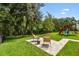Lush backyard featuring mature trees and playground set at 6214 Windship Ct, Tampa, FL 33647