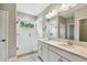 Modern bathroom with a double sink vanity, large mirror, and a glass-enclosed walk-in shower at 6214 Windship Ct, Tampa, FL 33647