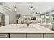 Open concept kitchen flowing to staircase, living room with white couch, and modern stainless steel appliances at 6214 Windship Ct, Tampa, FL 33647