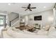 Open-concept living room with a comfortable sectional, sleek TV setup, and staircase access at 6214 Windship Ct, Tampa, FL 33647