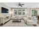 Bright living room with an oversized sectional couch, large windows, and stylish decor on hardwood floors at 6214 Windship Ct, Tampa, FL 33647