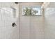 The tiled shower features a window to the exterior to brighten the space at 6214 Windship Ct, Tampa, FL 33647