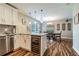 Kitchen with stainless steel appliances, wine fridge, breakfast bar, and hardwood floors open to dining room at 6635 9Th N Ave, St Petersburg, FL 33710