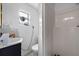 Modest bathroom featuring a sink, toilet, and shower stall, with a window for ventilation and natural light at 6807 N Himes Ave, Tampa, FL 33614