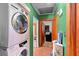 Functional laundry area featuring a stacked washer and dryer, tile flooring, and access to another room at 6807 N Himes Ave, Tampa, FL 33614