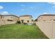 View of the backyard showcasing a well-manicured lawn, fencing, and surrounding homes at 6961 King Creek Dr, Sun City Center, FL 33573