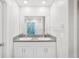 Bright bathroom featuring double sinks, granite counters, and a shower with a patterned curtain at 6961 King Creek Dr, Sun City Center, FL 33573